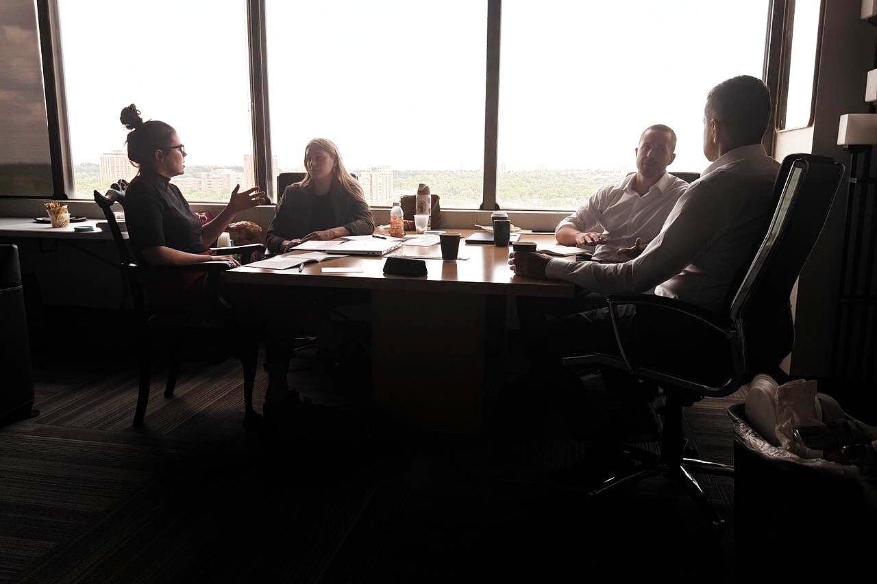 Cohort members in conversation at a table overlooking the St. Louis skyline